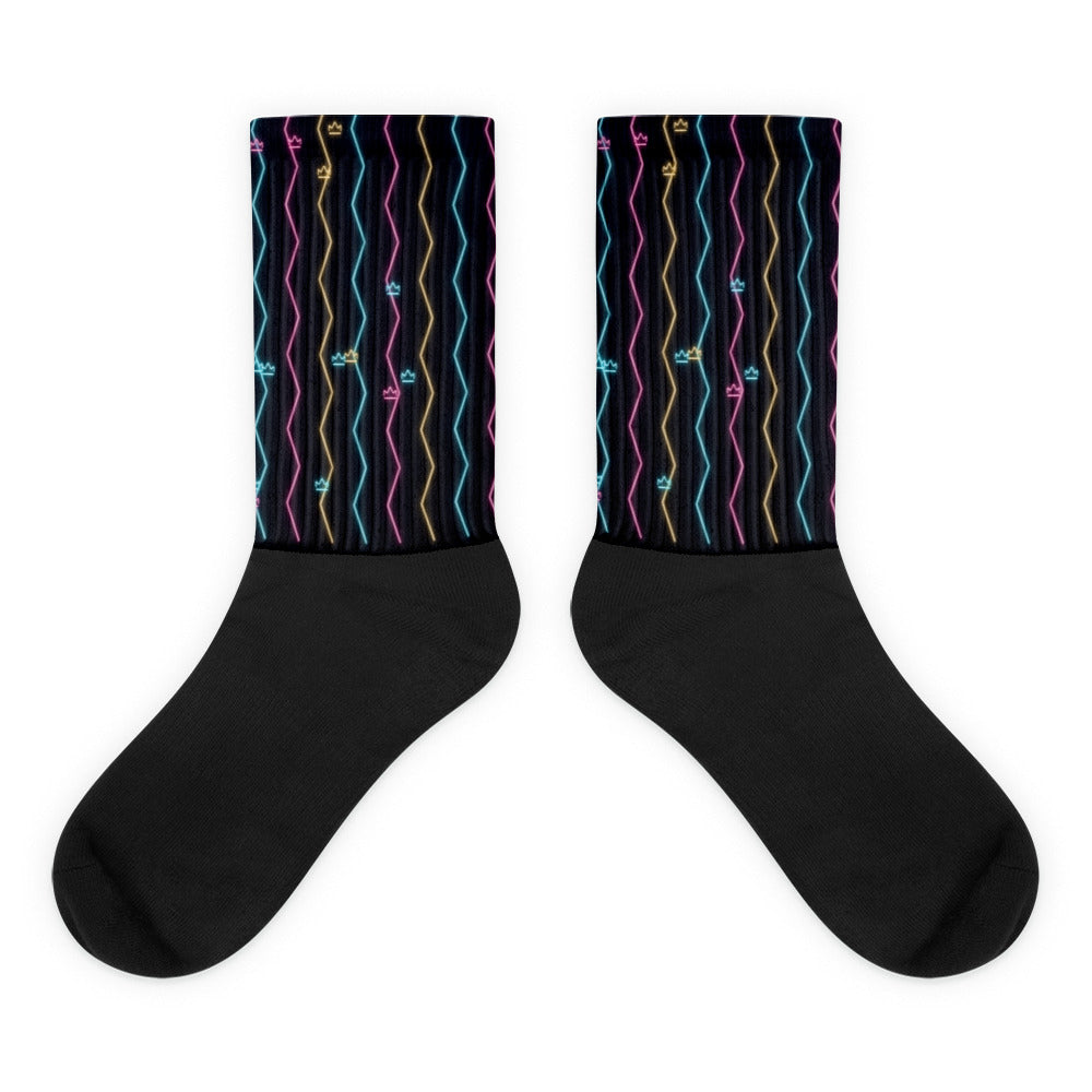 Calcetines con zigzags de neón cian, magenta y ámbar sobre fondo nocturno
